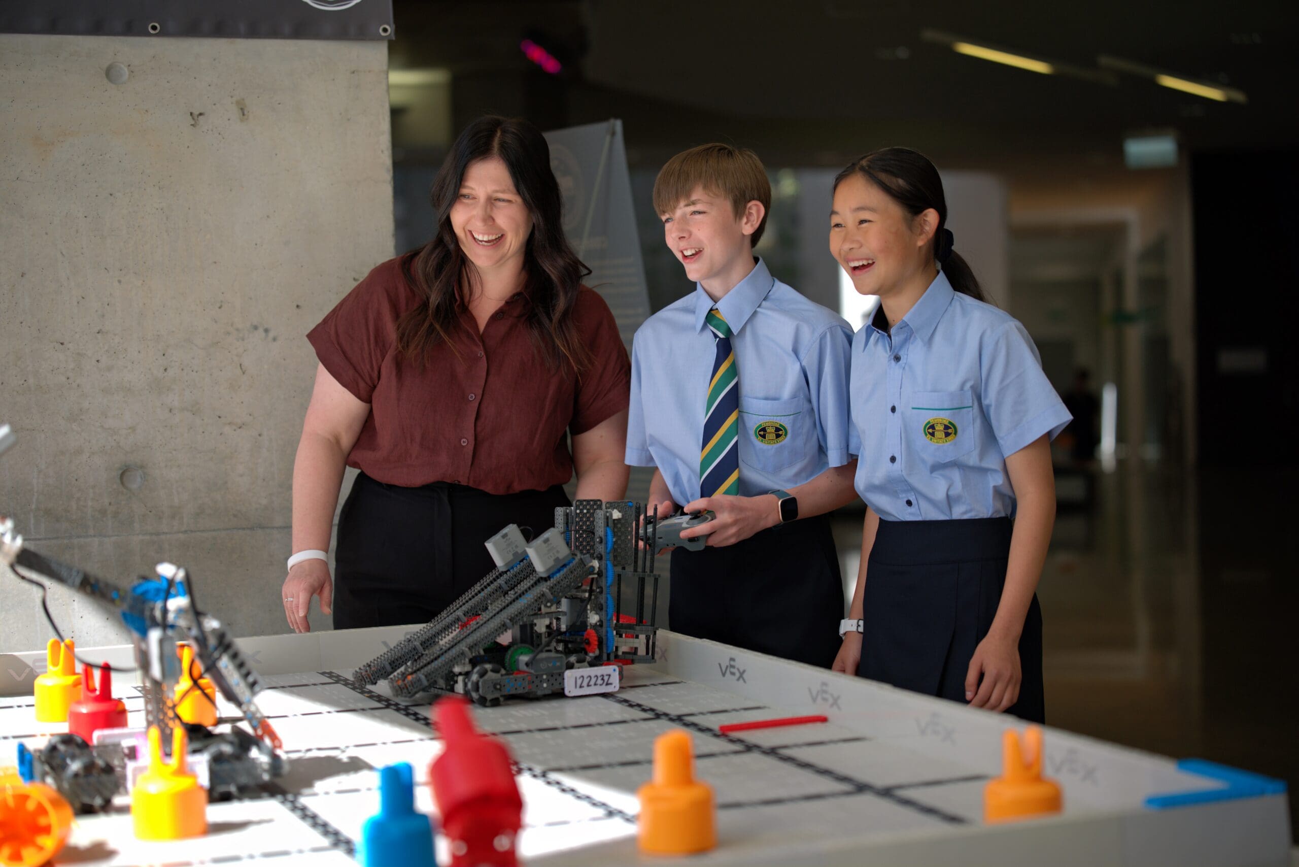 two students and a teacher in robotics lab