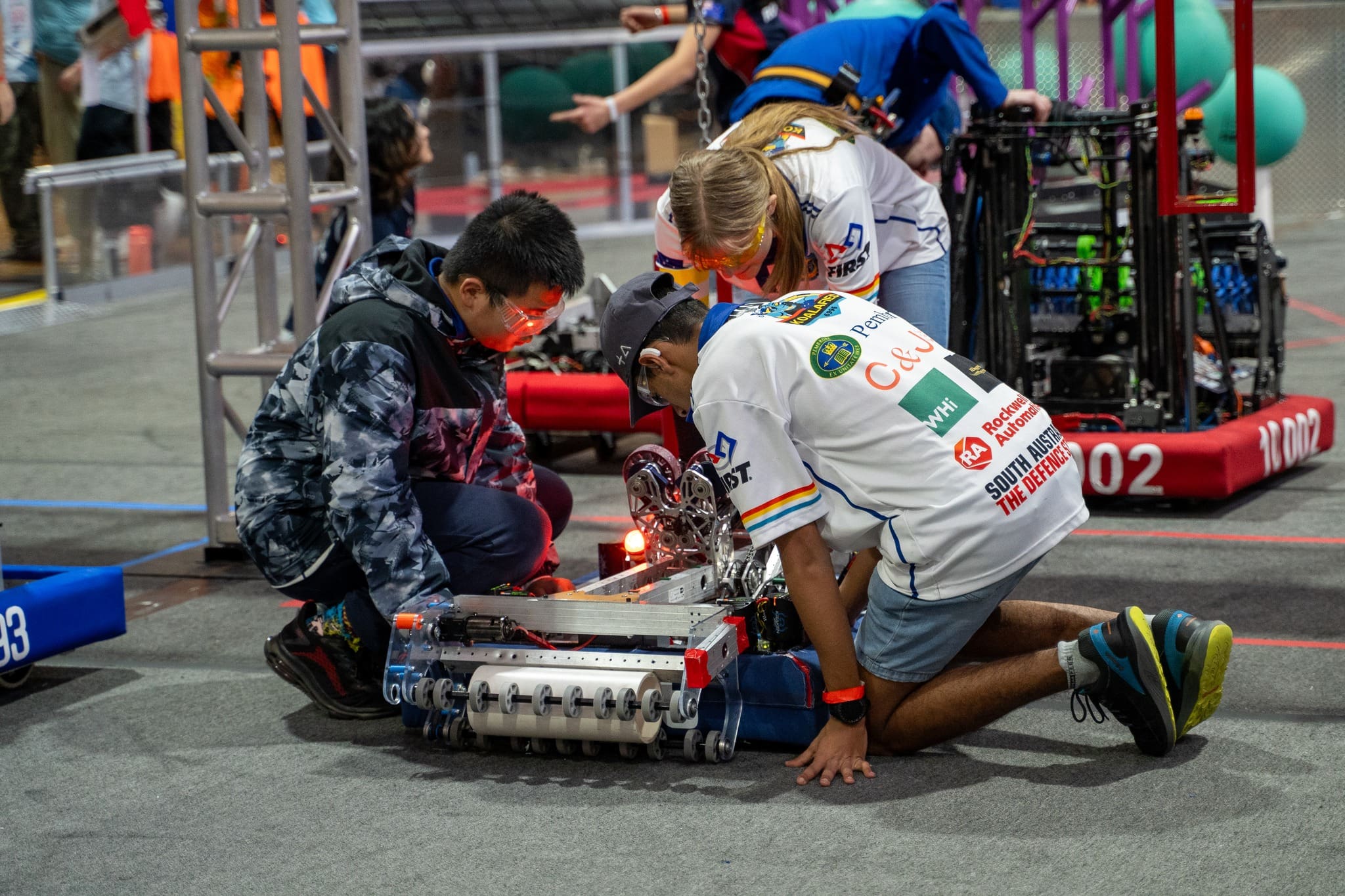 three students participating in robotics competition