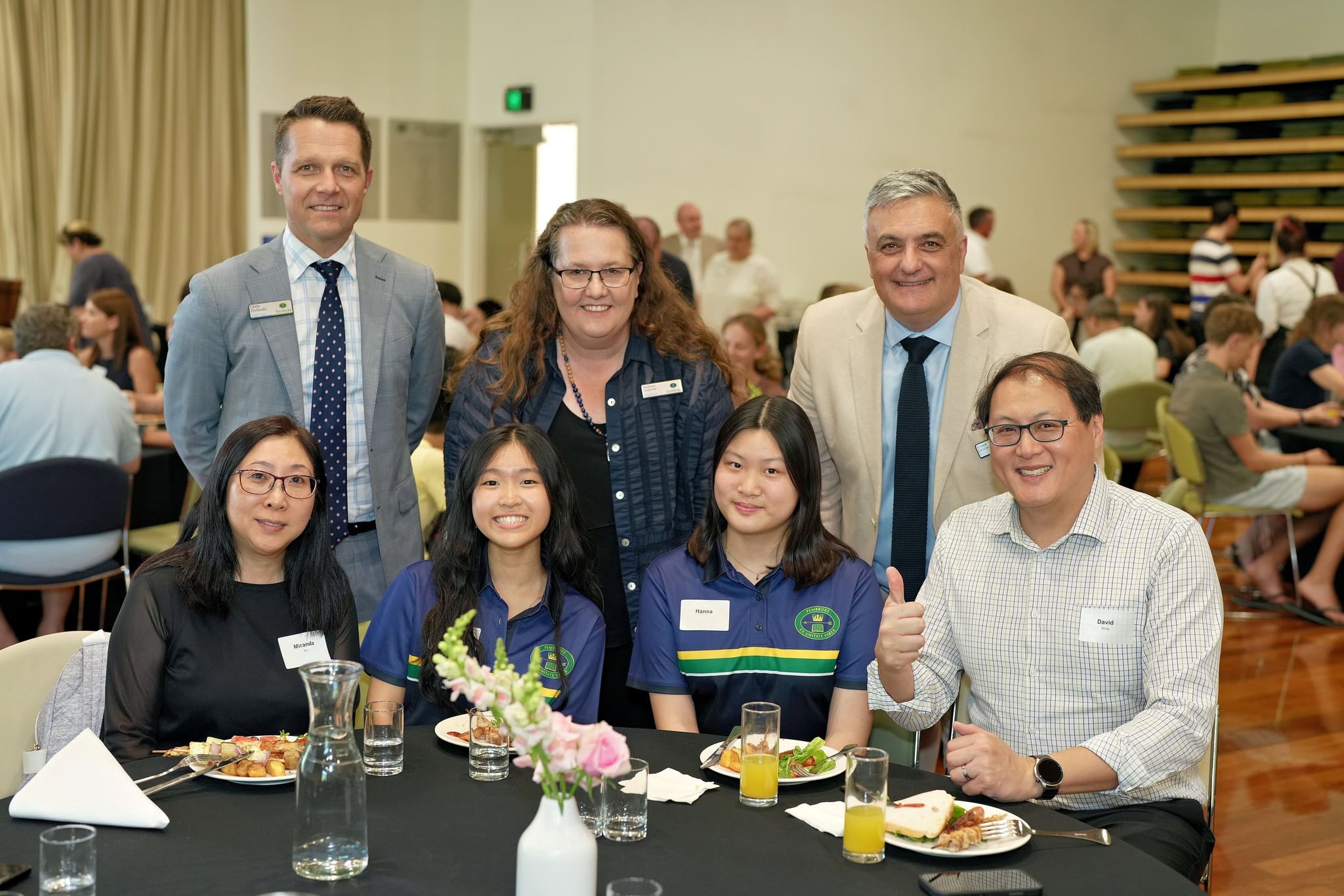 Boarders' Welcome BBQ Nov 2025 students, parents, staff and Board member at table in DY Hall