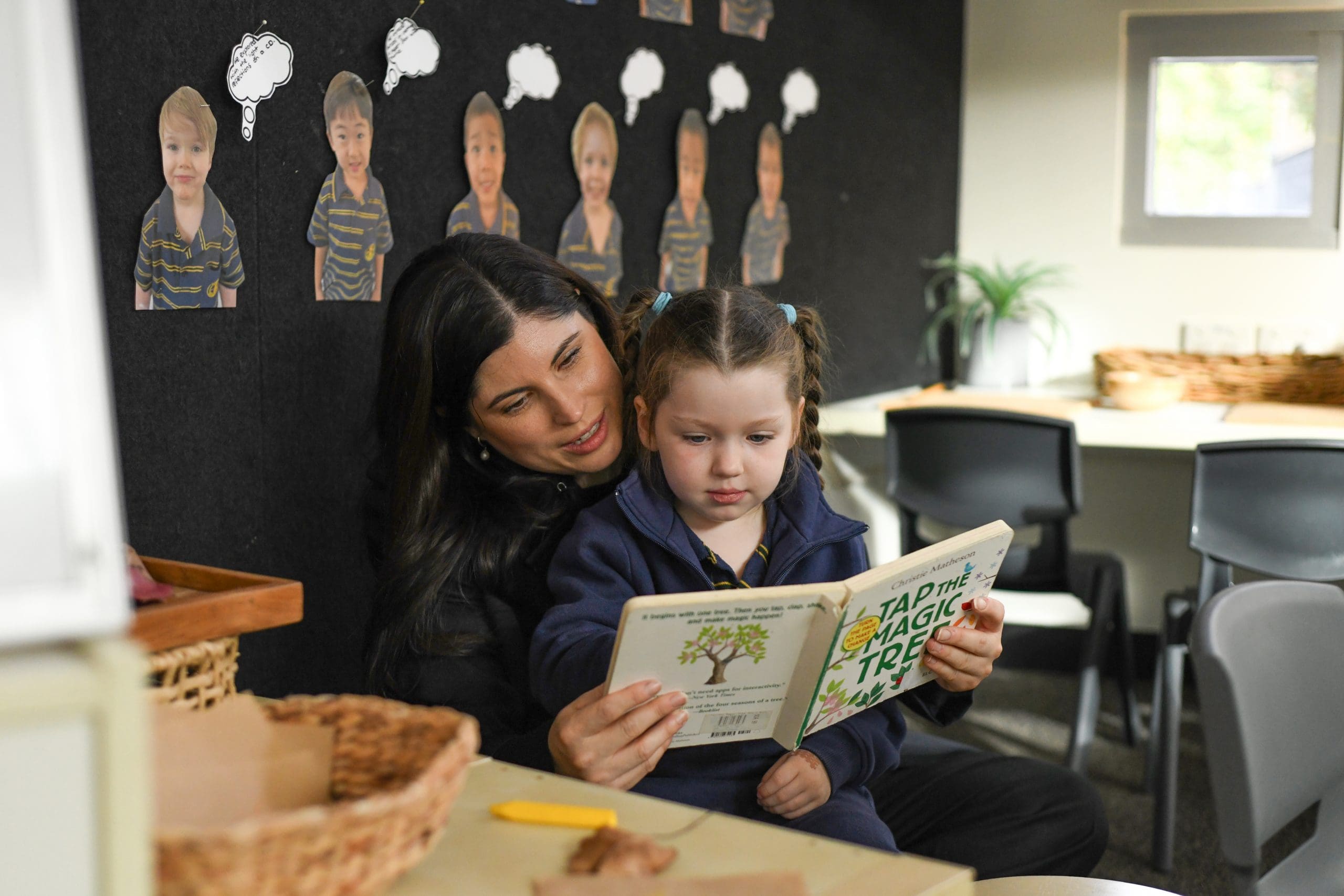 junior school mother reading a book with her daughter