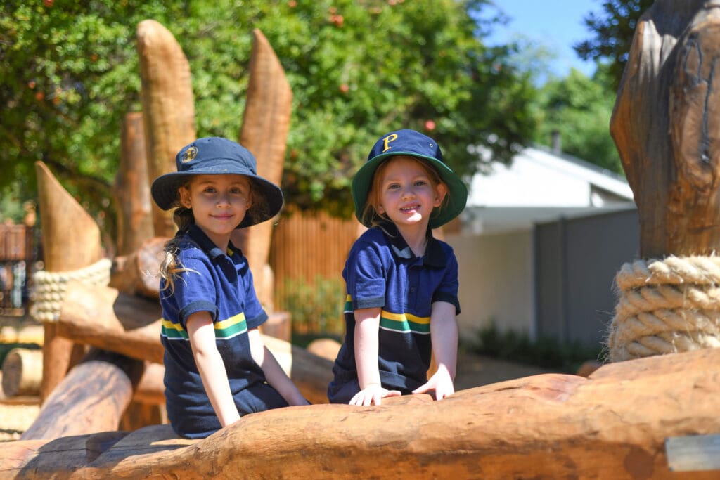 Two children playing on wooden structure