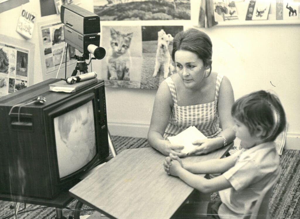 Hearing Unit 1977 educator with student in front of TV